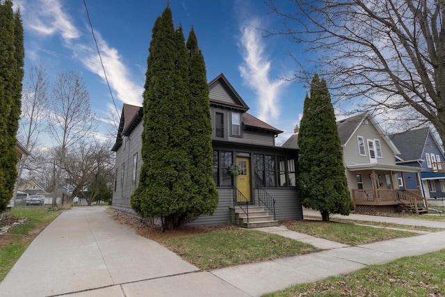view of front of home with entry steps, a chimney, and a residential view