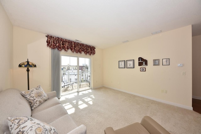 living area featuring baseboards, carpet flooring, and visible vents