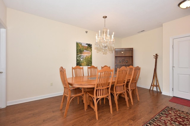 dining room featuring baseboards, an inviting chandelier, wood finished floors, and visible vents