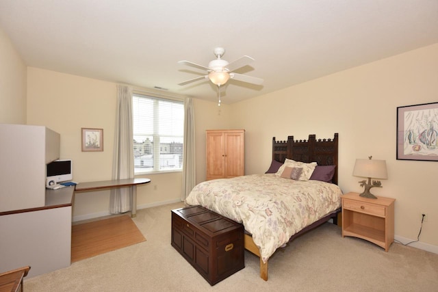 bedroom with ceiling fan, light colored carpet, and baseboards