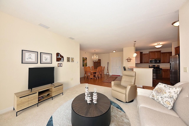 living area with an inviting chandelier, light carpet, and visible vents