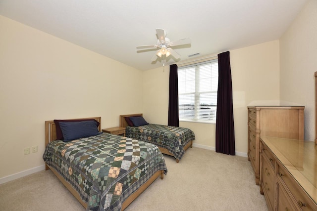 bedroom featuring baseboards, visible vents, light carpet, and ceiling fan