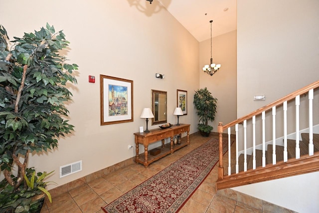 entryway featuring high vaulted ceiling, stairs, a chandelier, and visible vents