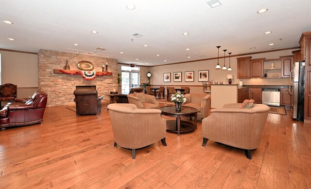 living area featuring recessed lighting, ornamental molding, and light wood finished floors