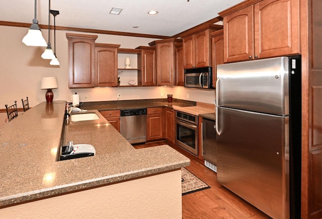 kitchen with hanging light fixtures, open shelves, a sink, ornamental molding, and stainless steel appliances