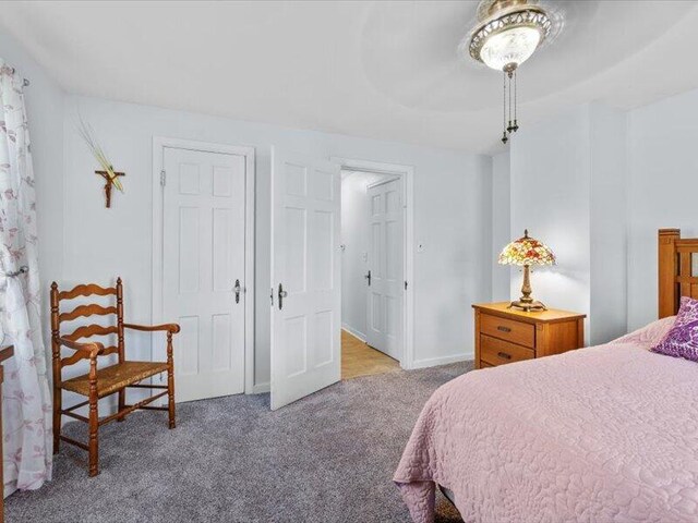 carpeted bedroom featuring baseboards and ceiling fan