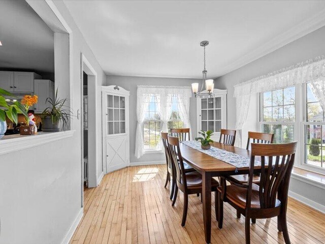 dining room featuring an inviting chandelier, baseboards, and light wood finished floors