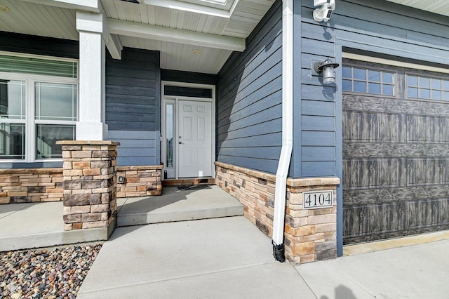 property entrance featuring covered porch and stone siding