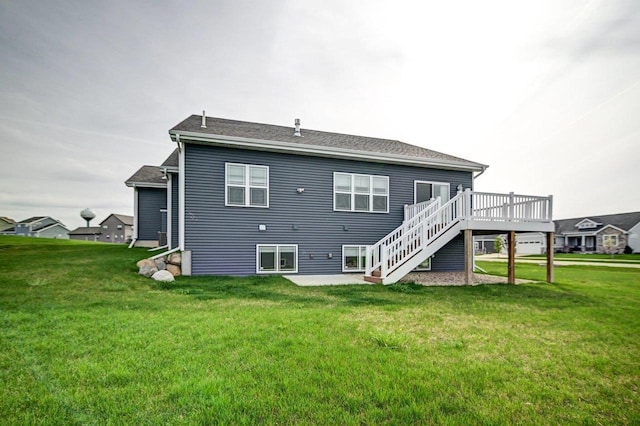 rear view of property featuring a lawn, stairway, and a deck