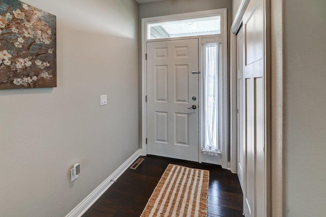 foyer entrance featuring dark wood-type flooring and baseboards