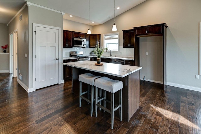 kitchen featuring dark brown cabinetry, dark wood finished floors, a center island, stainless steel appliances, and recessed lighting