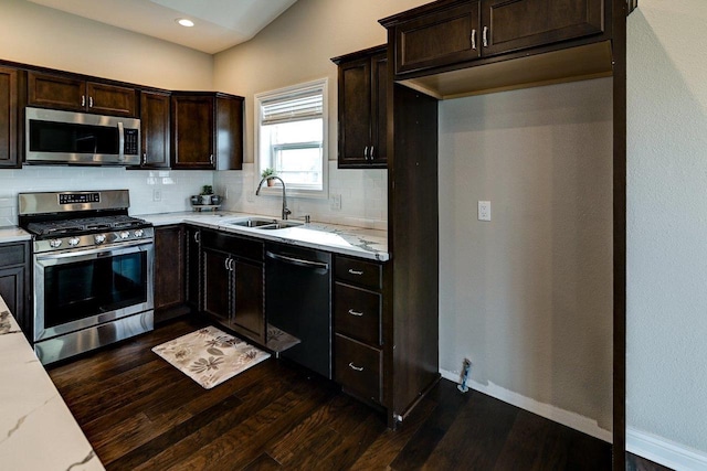 kitchen featuring decorative backsplash, dark wood-style flooring, dark brown cabinets, a sink, and stainless steel appliances
