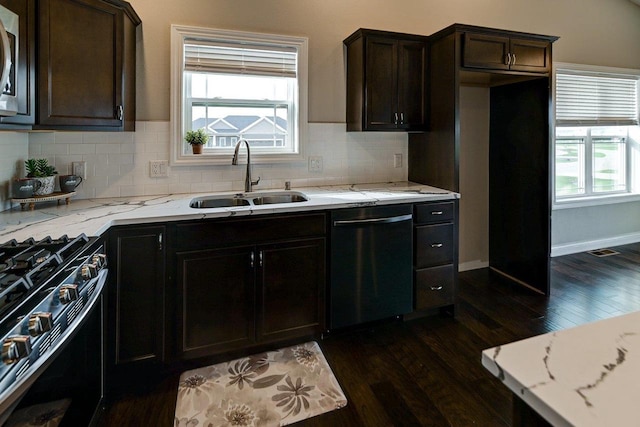 kitchen featuring a sink, dark wood-style flooring, appliances with stainless steel finishes, and light stone countertops
