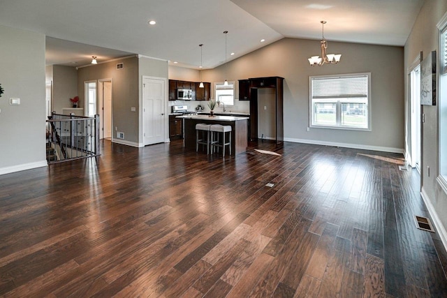 unfurnished living room featuring visible vents, an inviting chandelier, dark wood finished floors, and lofted ceiling