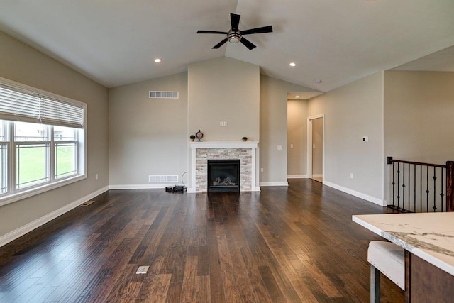 unfurnished living room with visible vents, a ceiling fan, dark wood-style floors, and vaulted ceiling