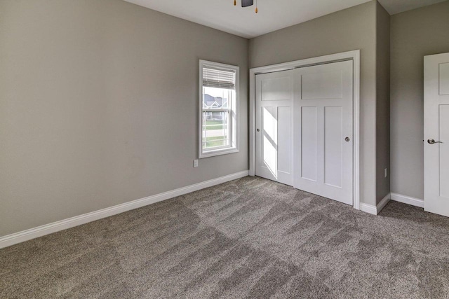 unfurnished bedroom featuring carpet floors, baseboards, and a closet
