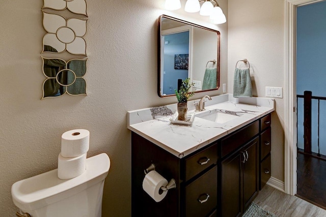 bathroom with toilet, wood finished floors, and vanity