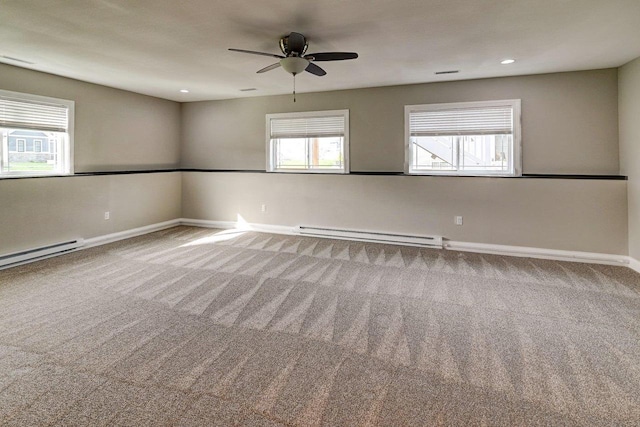 carpeted spare room featuring baseboards, ceiling fan, and a baseboard heating unit