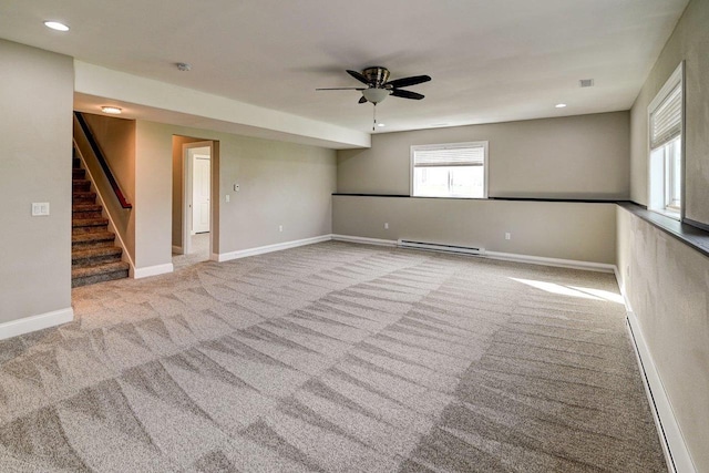 unfurnished room featuring stairs, baseboards, ceiling fan, a baseboard heating unit, and carpet