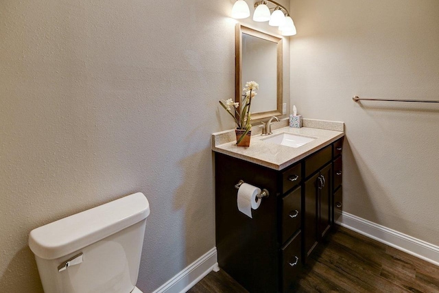 bathroom featuring vanity, baseboards, toilet, and wood finished floors