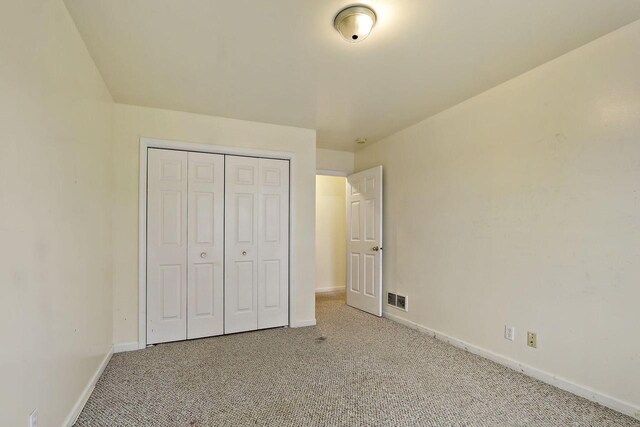 956 Williams St, Walworth, WI 53184 - unfurnished bedroom with light colored carpet, baseboards, visible vents, and a closet