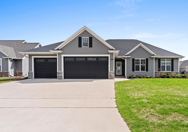 craftsman-style house with concrete driveway, a front yard, an attached garage, and stone siding