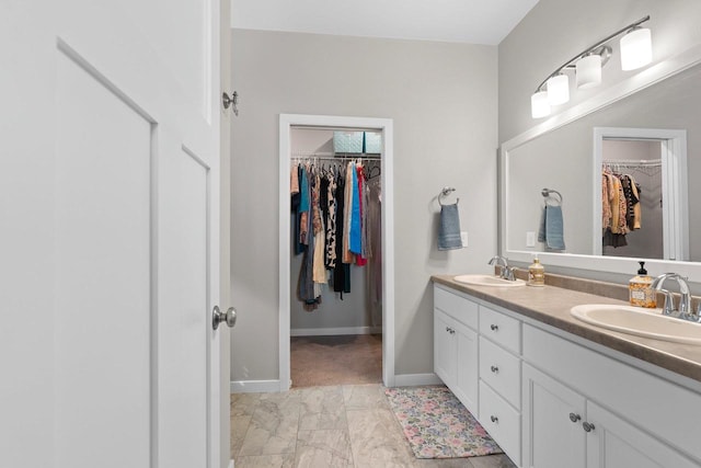 full bathroom with a sink, baseboards, double vanity, and marble finish floor