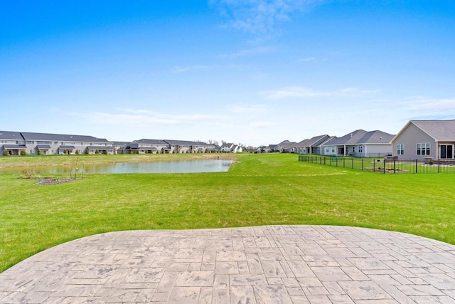 exterior space with a water view, fence, a residential view, and a patio