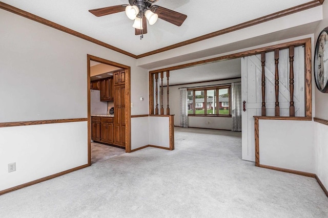 empty room with baseboards, ceiling fan, light carpet, and ornamental molding