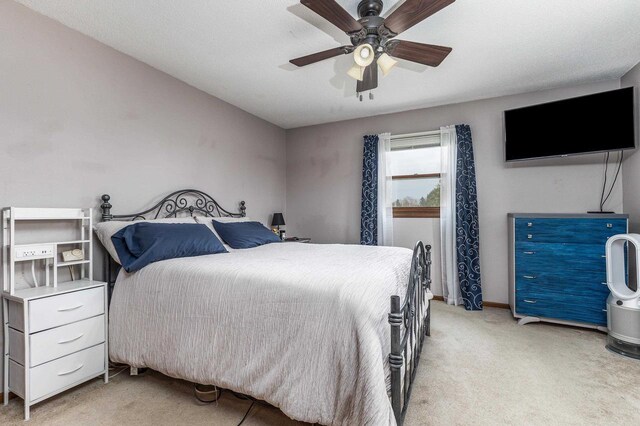bedroom featuring baseboards, ceiling fan, and light carpet