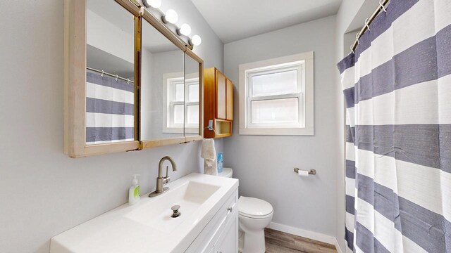 full bathroom with vanity, toilet, a shower with shower curtain, baseboards, and wood finished floors