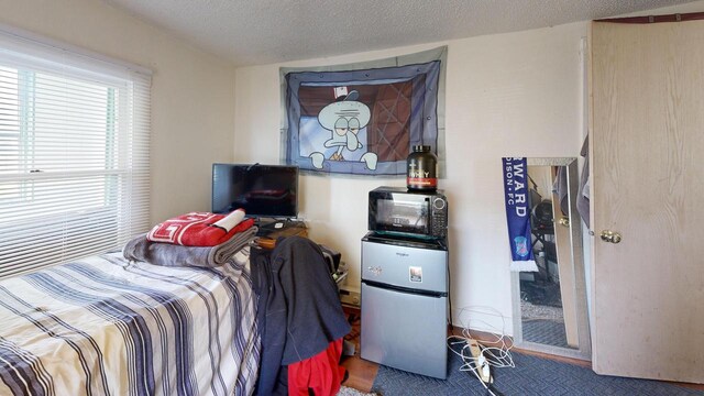 bedroom with freestanding refrigerator