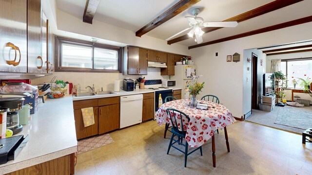kitchen featuring a sink, white appliances, light countertops, light floors, and under cabinet range hood