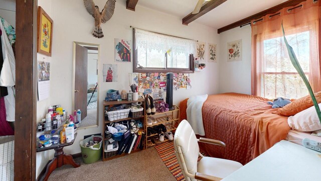 carpeted bedroom with beamed ceiling