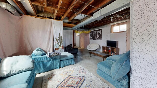 living area with unfinished concrete flooring