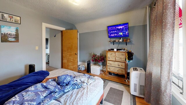 bedroom featuring vaulted ceiling and a textured ceiling