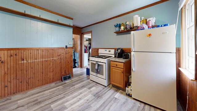 kitchen featuring visible vents, open shelves, wood walls, light wood-type flooring, and white appliances