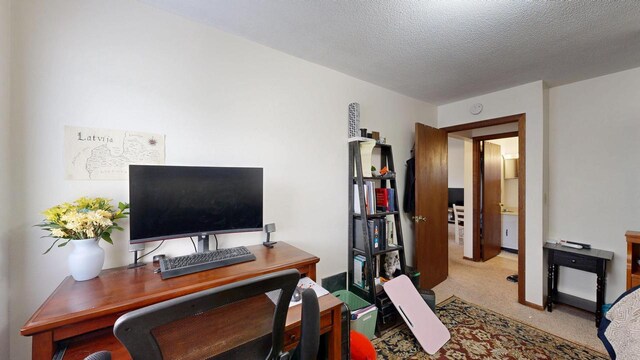 carpeted office with a textured ceiling