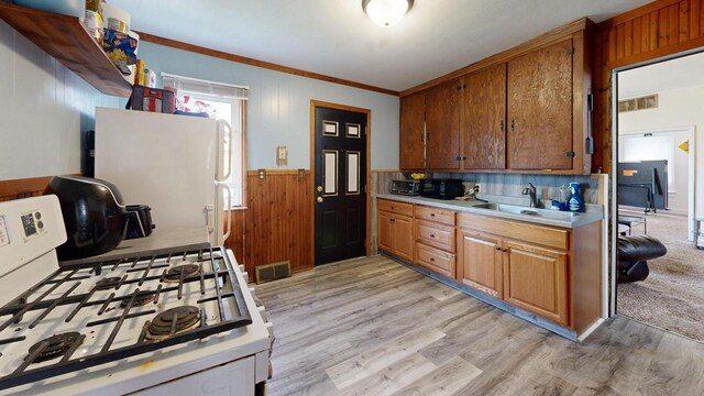 kitchen with visible vents, white appliances, light wood-style floors, light countertops, and a sink