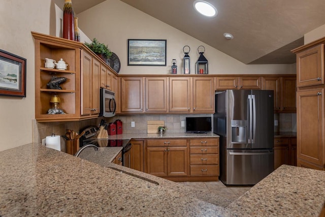 kitchen with brown cabinetry, lofted ceiling, light stone countertops, and stainless steel appliances