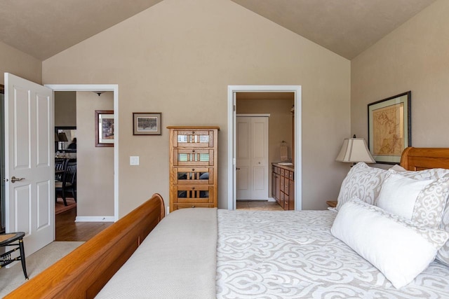 bedroom with baseboards, ensuite bathroom, high vaulted ceiling, and light colored carpet