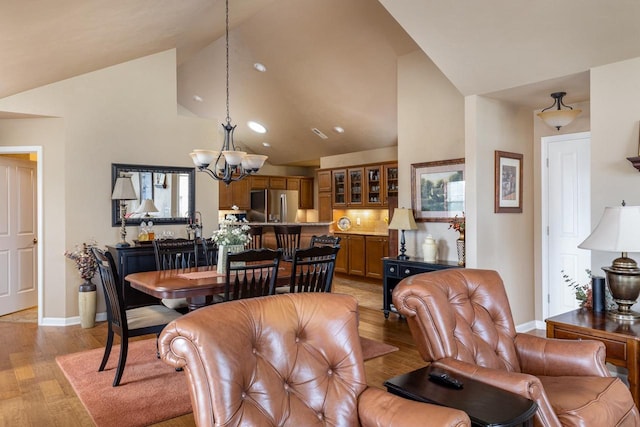 dining area with recessed lighting, baseboards, light wood-type flooring, and a chandelier