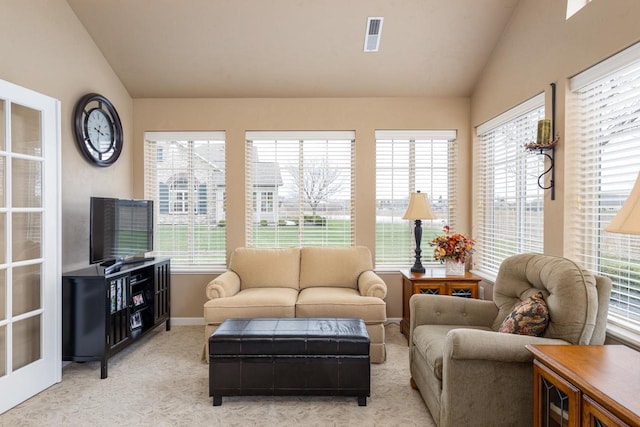 living area featuring a wealth of natural light, light colored carpet, and lofted ceiling