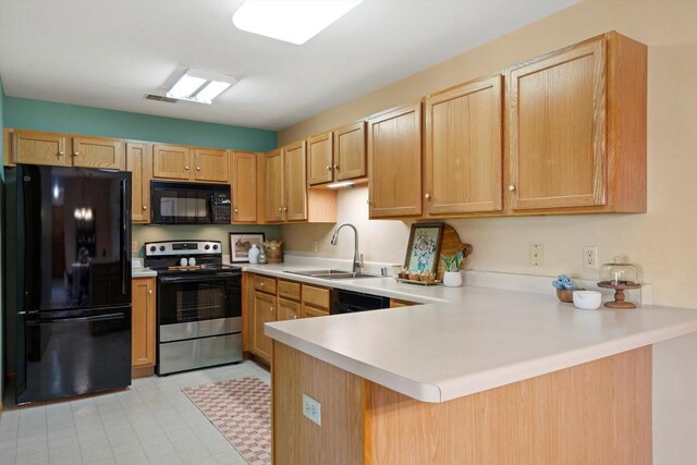 kitchen featuring a sink, light countertops, a peninsula, visible vents, and black appliances