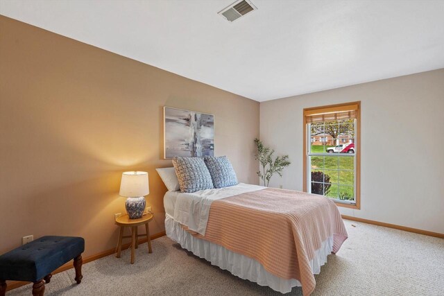 bedroom with visible vents, baseboards, and light carpet