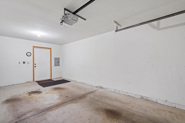 garage with a garage door opener and electric panel