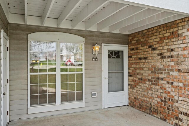 doorway to property featuring brick siding