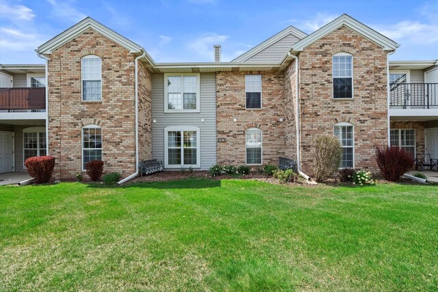 view of front of property featuring brick siding and a front lawn