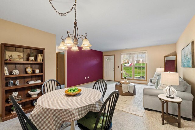 dining space with carpet flooring and an inviting chandelier