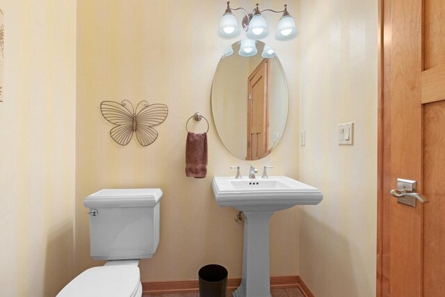 half bath with toilet and baseboards
